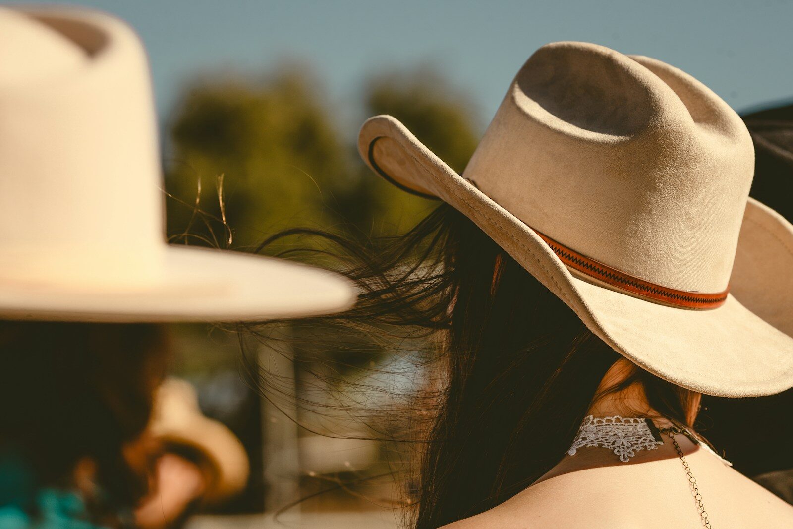 Cowboys wear hats in the sunny outdoors.