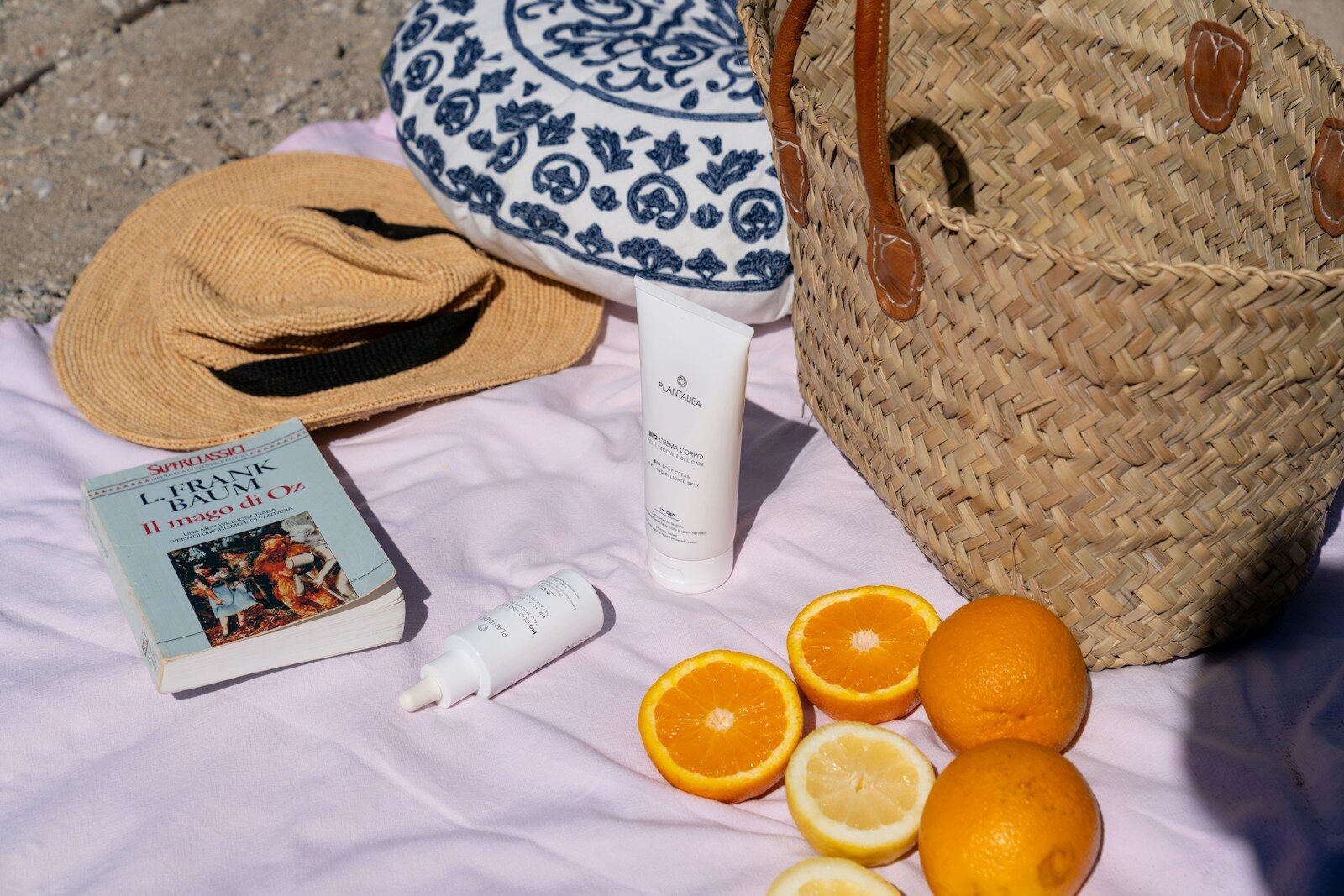 Beach essentials: fruit, sun protection, and a straw bag.