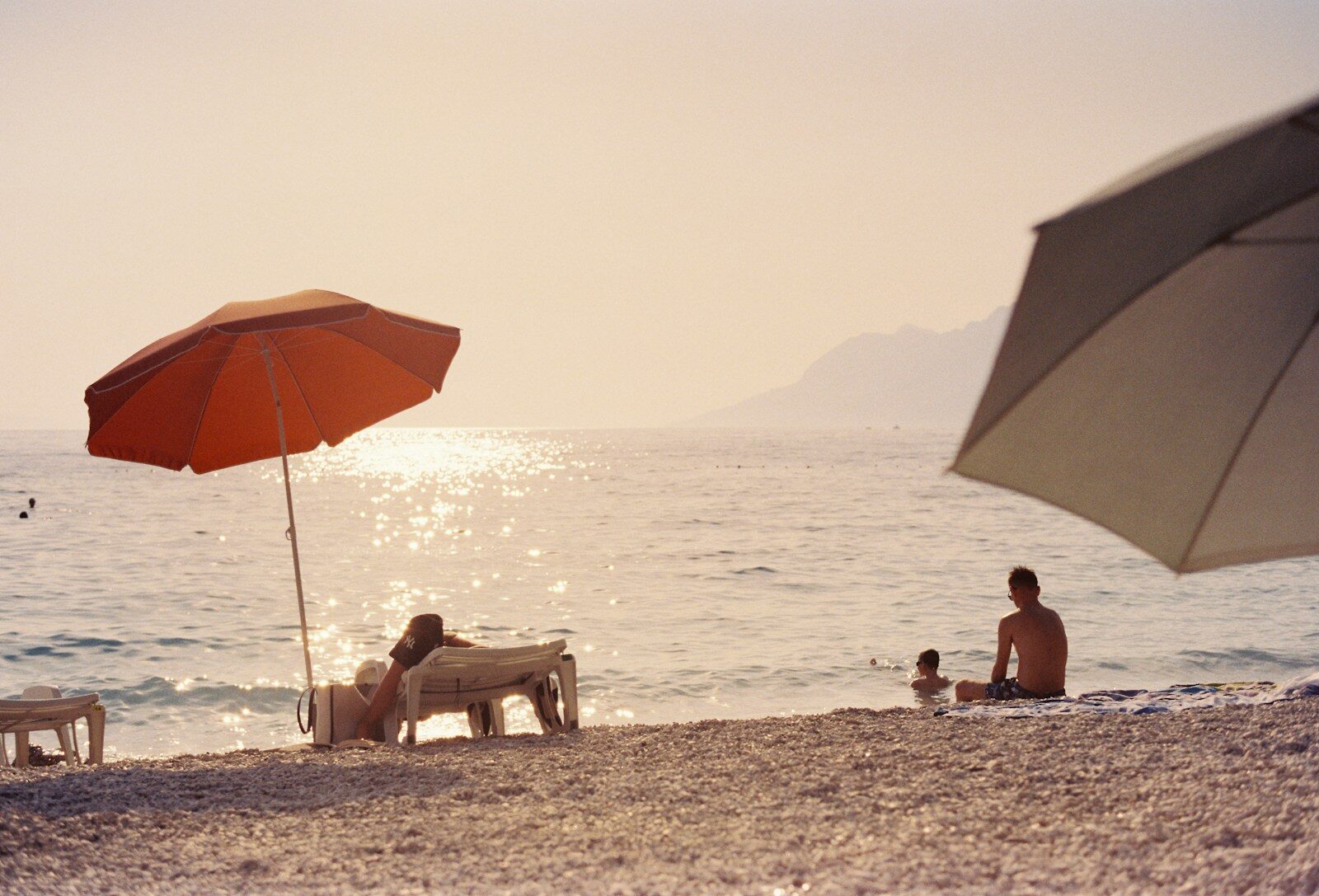 A group of people sitting on top of a sandy beach